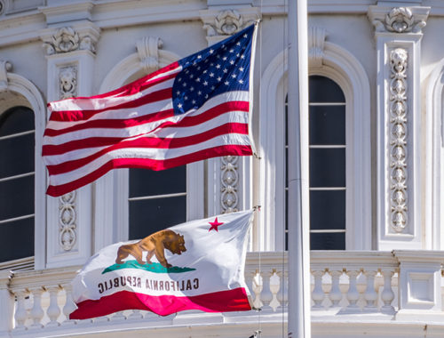 The California state flag flying before the copital dome in Sacramento